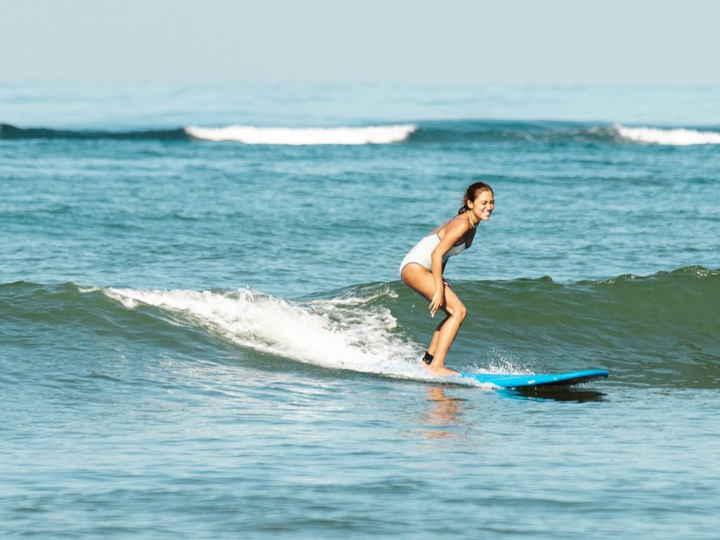 a woman surfing a wave in Siargao