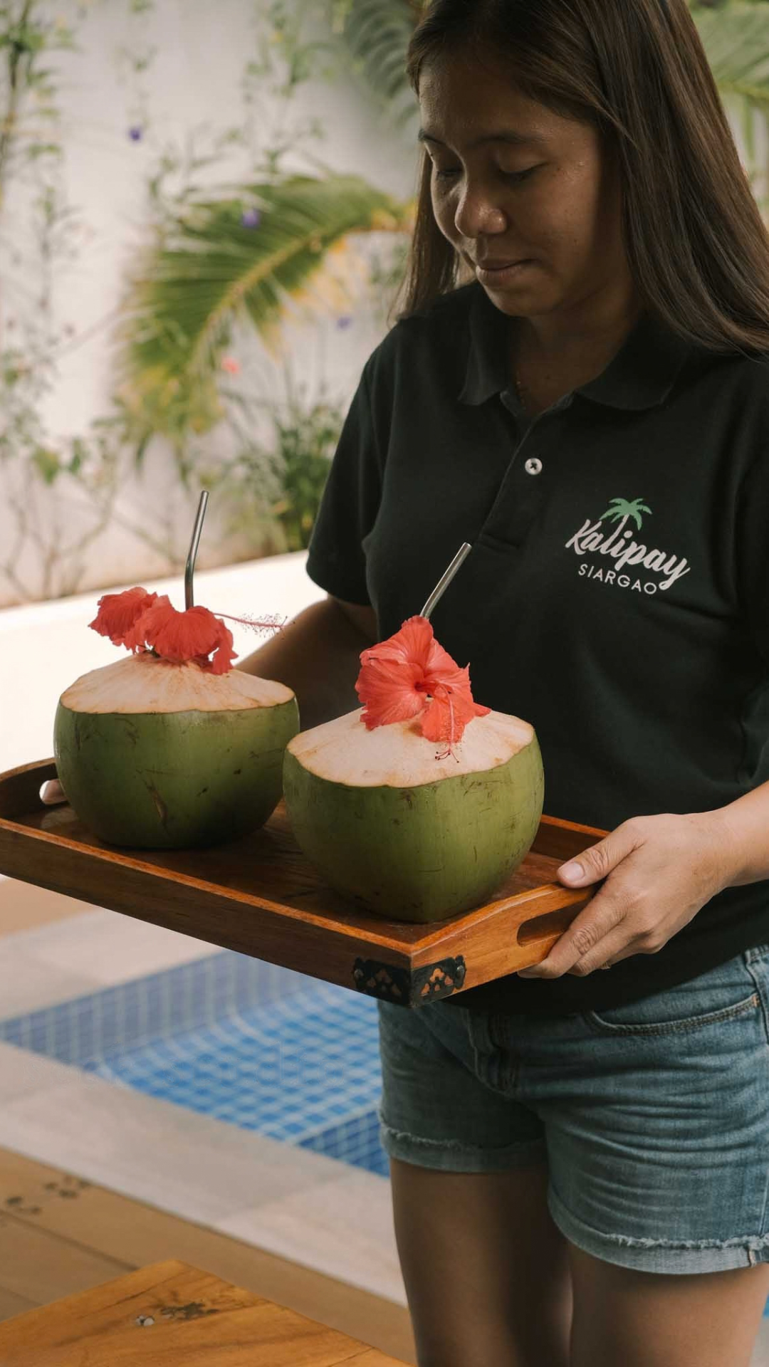 A Kalipay team member serving fresh coconut welcome drinks
